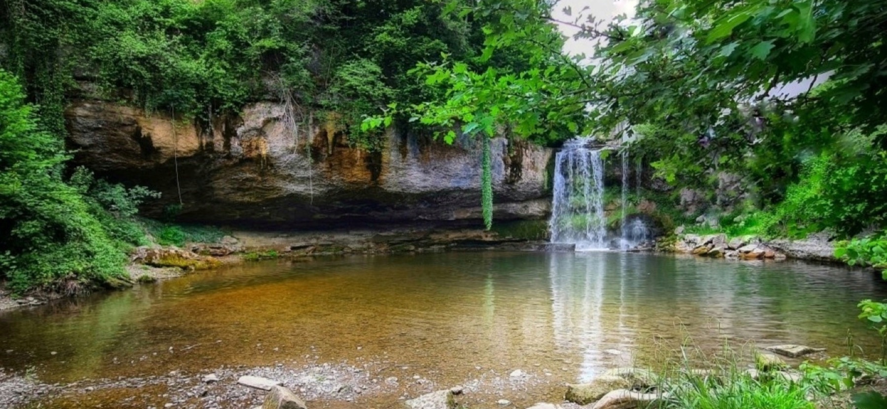 Wasserfall an einem ruhigen Waldsee